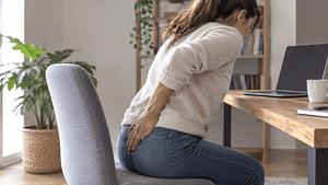 Dolor de cócix mujer sentada frente a escritorio